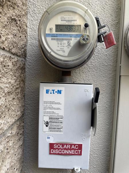 Revenue-grade meter and Solar AC Disconnect mounted on exterior wall — installed 2011